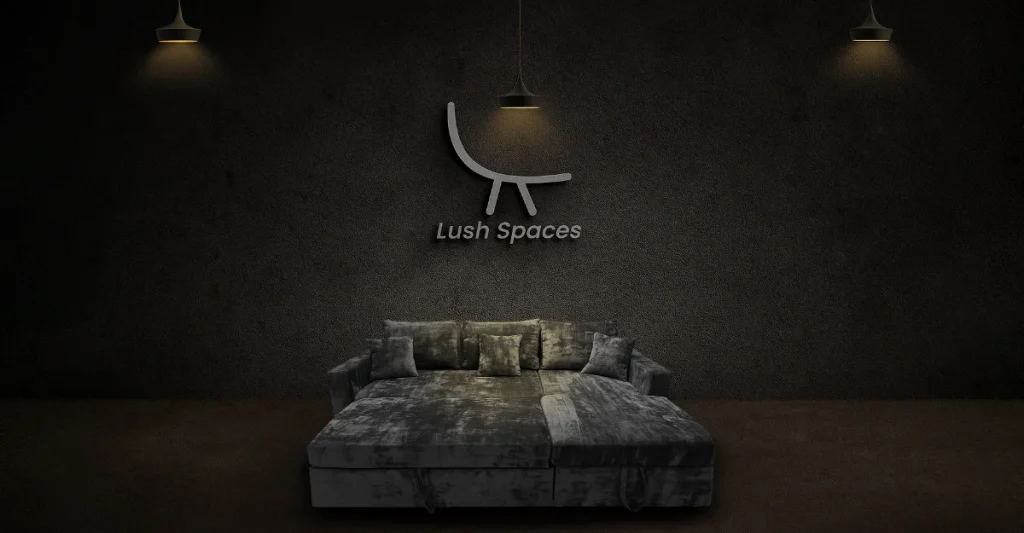 A neatly made sofa cum bed with a white sheet and a wall-mounted lamp illuminating the space.